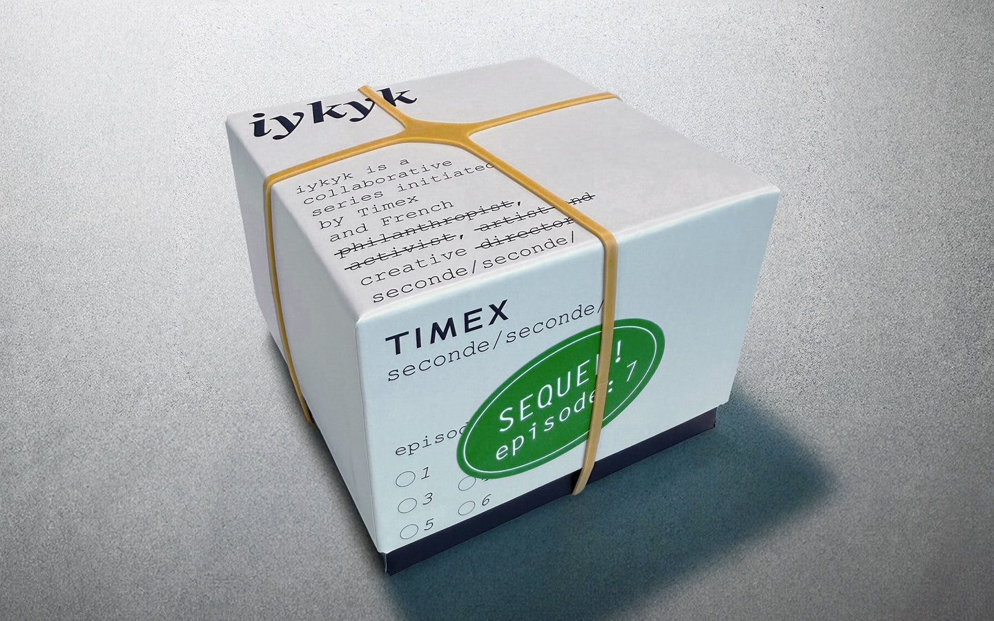 Timex x seconde/seconde/ Episode 7 packaging box secured with rubber bands. The box features stylized type with humorous strikethrough edits and a green sticker labeled 'SEQUEL! episode 7'.