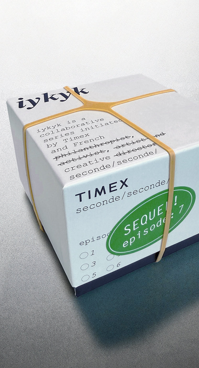 Timex x seconde/seconde/ Episode 7 packaging box secured with rubber bands. The box features stylized type with humorous strikethrough edits and a green sticker labeled 'SEQUEL! episode 7'.