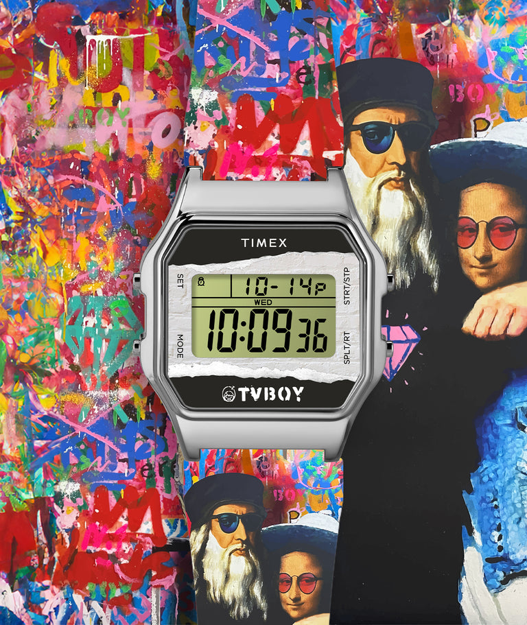 A Timex digital wristwatch with a silver rectangular case is displayed over a vibrant graffiti-style background. The watch screen shows the date "10-14" and time "10:09:36" on a greenish display. The bottom of the watch features the TVBOY logo. Behind the watch, a colorful mural includes abstract spray paint layers and a stylized illustration of two figures resembling classical Renaissance portraits wearing modern sunglasses.