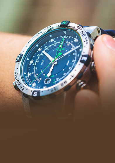 Angled wrist shot of the Timex Expedition Tide-Temp-Compass watch with blue dial, compass bezel, luminous hands, and green tide indicators, emphasizing its rugged outdoor design.