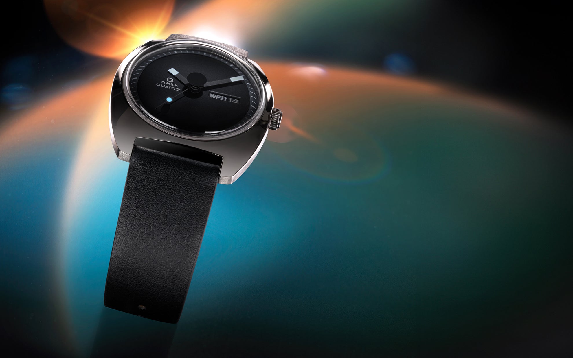 Stylized lifestyle shot of the Q Timex® 1975 Enigma watch floating over a cosmic-themed background. The watch’s sleek design, leather strap, and gleaming case are highlighted with dramatic lighting.