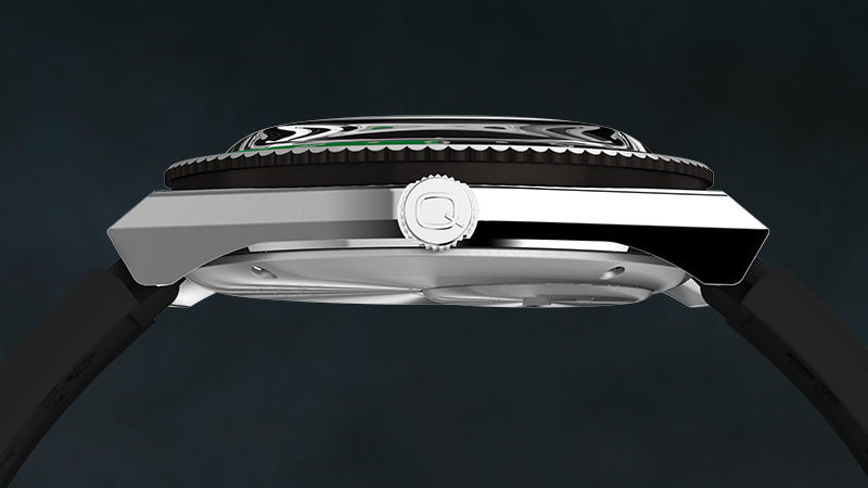 Side profile view of the Q Timex GMT watch, highlighting the polished stainless steel case, domed crystal, and ridged bezel. The crown is engraved with the “Q” logo and flanked by a black strap. The clean silhouette emphasizes the slim, angular design against a dark, moody background.