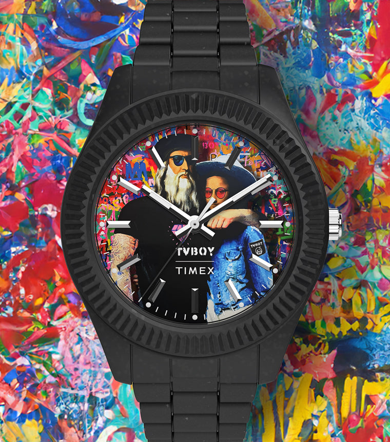 Timex Legacy Ocean x TVBOY analog watch with a black case and bracelet set against a vibrant, multicolored graffiti-style background. The dial features street artist TVBOY’s artwork of a modernized Leonardo da Vinci and Mona Lisa wearing sunglasses and casual attire.