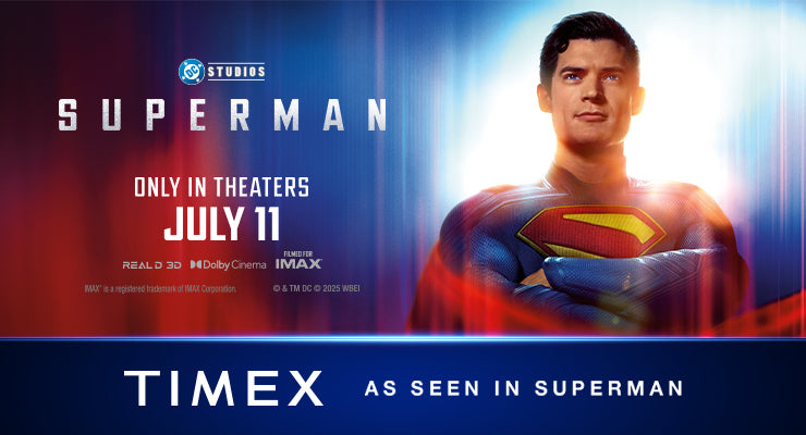 Promotional banner for the upcoming Superman movie from DC Studios, premiering in theaters on July 11. The banner features Superman standing heroically with a glowing background, wearing his iconic red and blue suit with a yellow “S” emblem on his chest. On the right side, the Timex logo appears with the tagline “As Seen in Superman,” indicating a brand partnership.