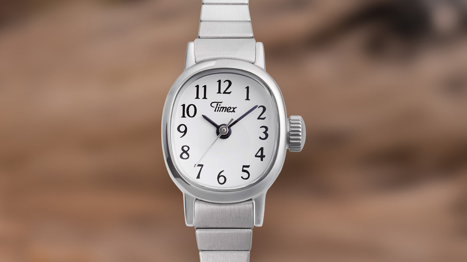 Front close-up of the Timex Cavatina Mini watch, featuring a polished silver case, white dial, and black Arabic numerals.