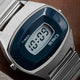 Close-up of the Q Timex® 1975 SSQ Digital Reissue dial showing the rectangular digital display framed by a deep blue bezel and the SSQ logo beneath the screen.