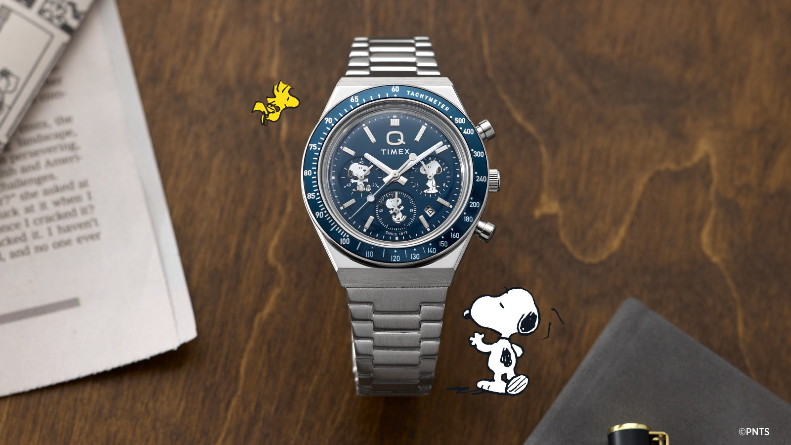 Timex x Peanuts® Q Timex® Chronograph displayed with Snoopy comic strip artwork featuring Lucy and Snoopy, connecting the watch’s design inspiration to classic Peanuts® storytelling.