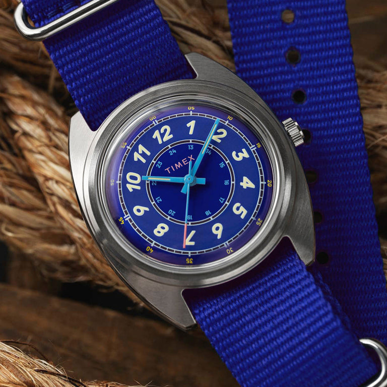 A detailed shot of the Timex x Worn & Wound Whirlpool watch resting on thick rope, highlighting the bold blue dial, cream numerals, and sturdy blue strap.