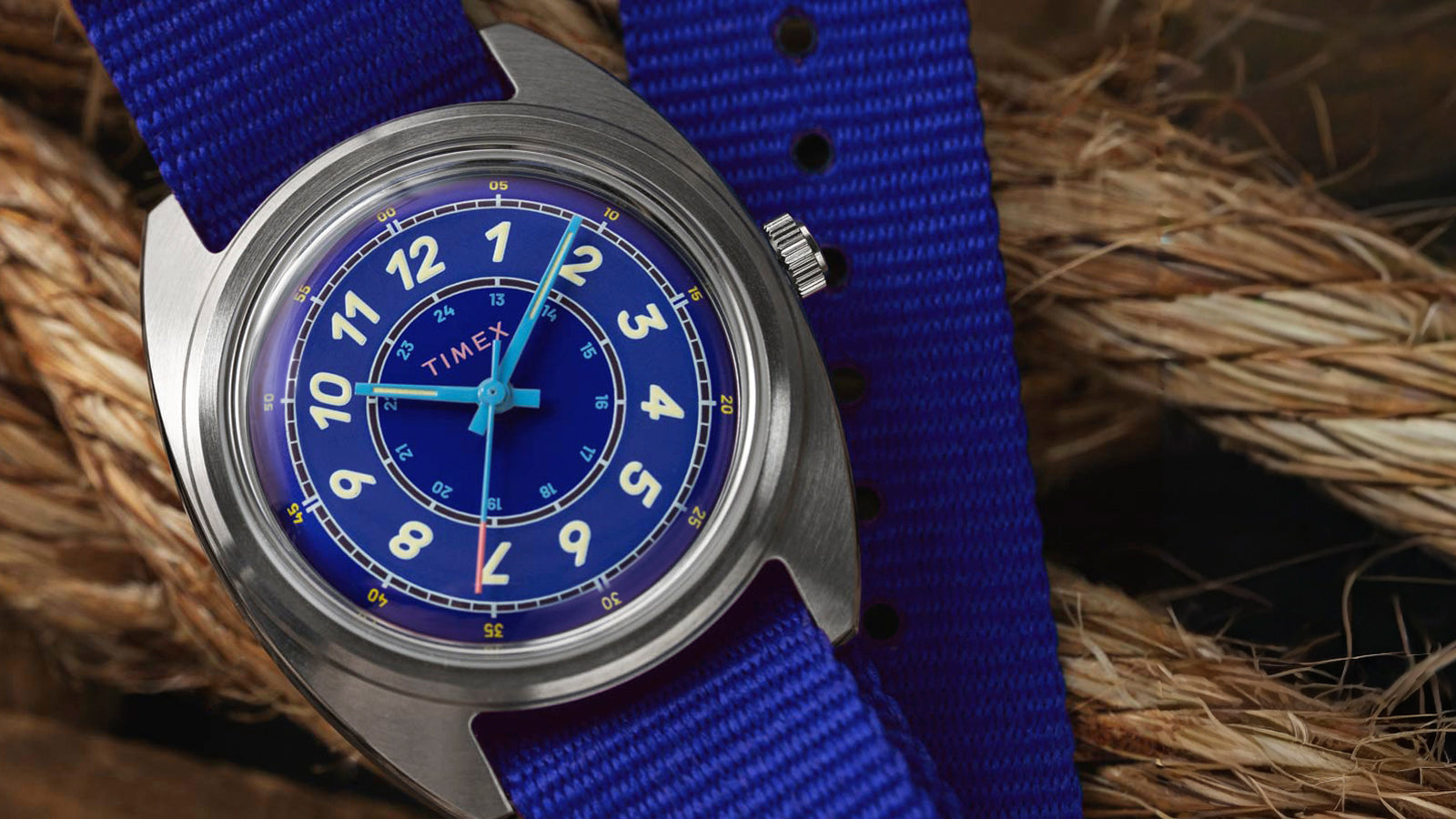 A close-up of the Timex x Worn & Wound Whirlpool dial displaying blue tones, cream numerals, and subtle minute markings, set against a rope background.
