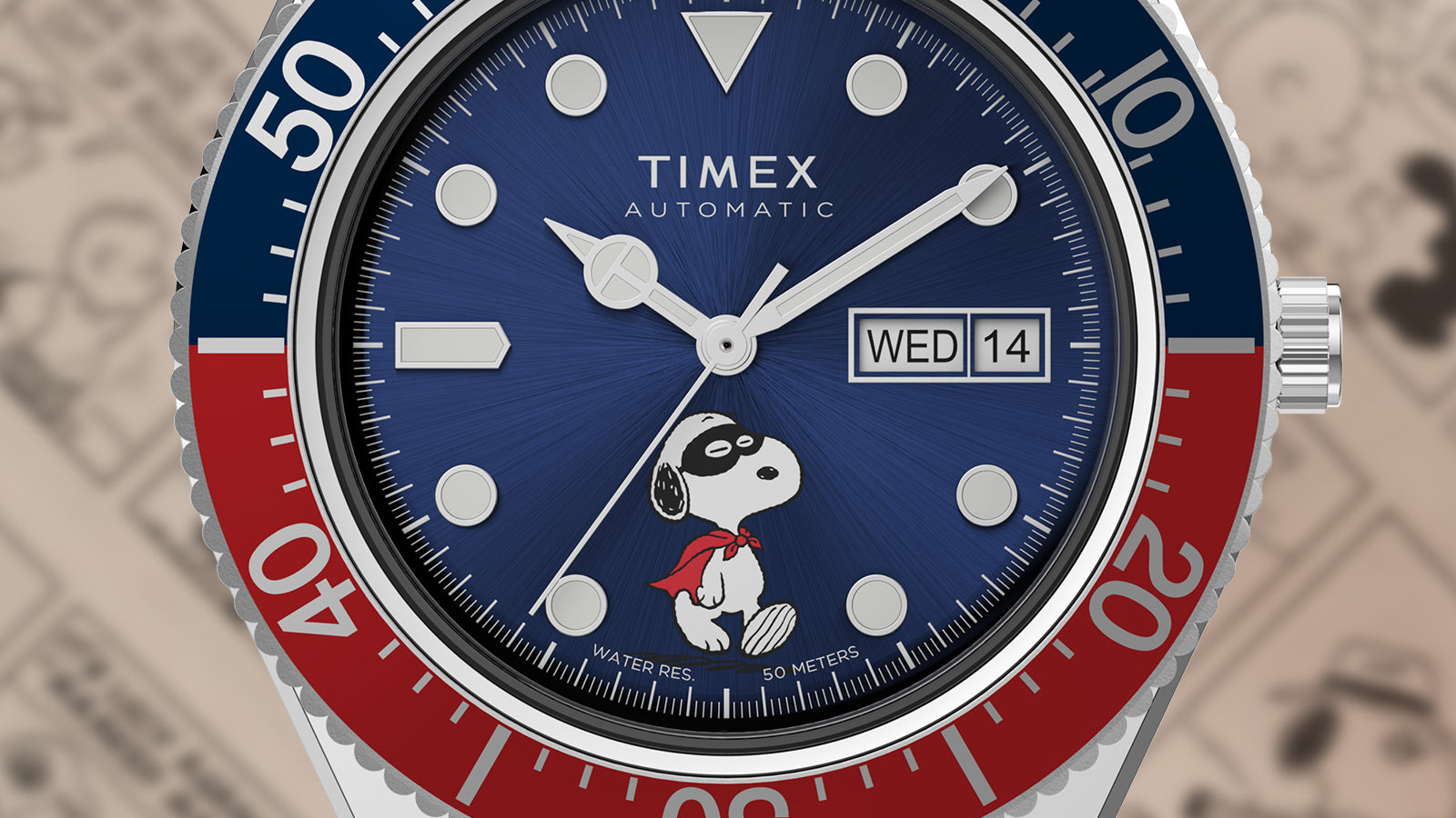 Macro view of the Timex M79 Automatic x Peanuts watch dial showing Snoopy in a red superhero cape on the blue background. The day-date display appears at 3 o’clock, and the red and blue bezel adds a bold contrast.