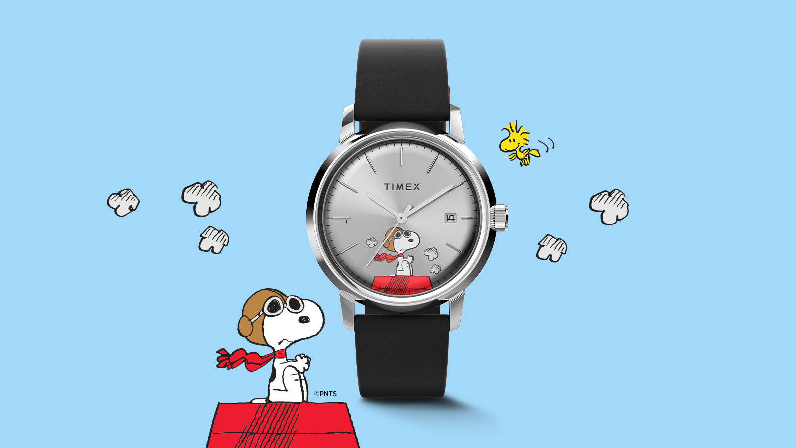 Front-facing view of the Timex Marlin® Automatic x Peanuts Snoopy Flying Ace watch on a sky-blue background with cloud illustrations. Snoopy, in his aviator goggles and red scarf, is depicted on the silver dial sitting on his red doghouse, adding whimsy to the classic Marlin design.