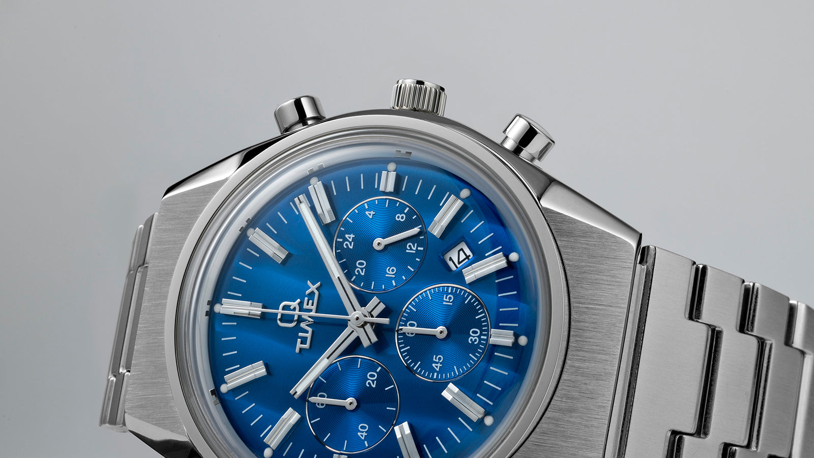 Macro view of the Q Timex Falcon Eye Chronograph dial showing intricate guilloché detailing on the subdials, polished hour markers, and date window at 4 o’clock.