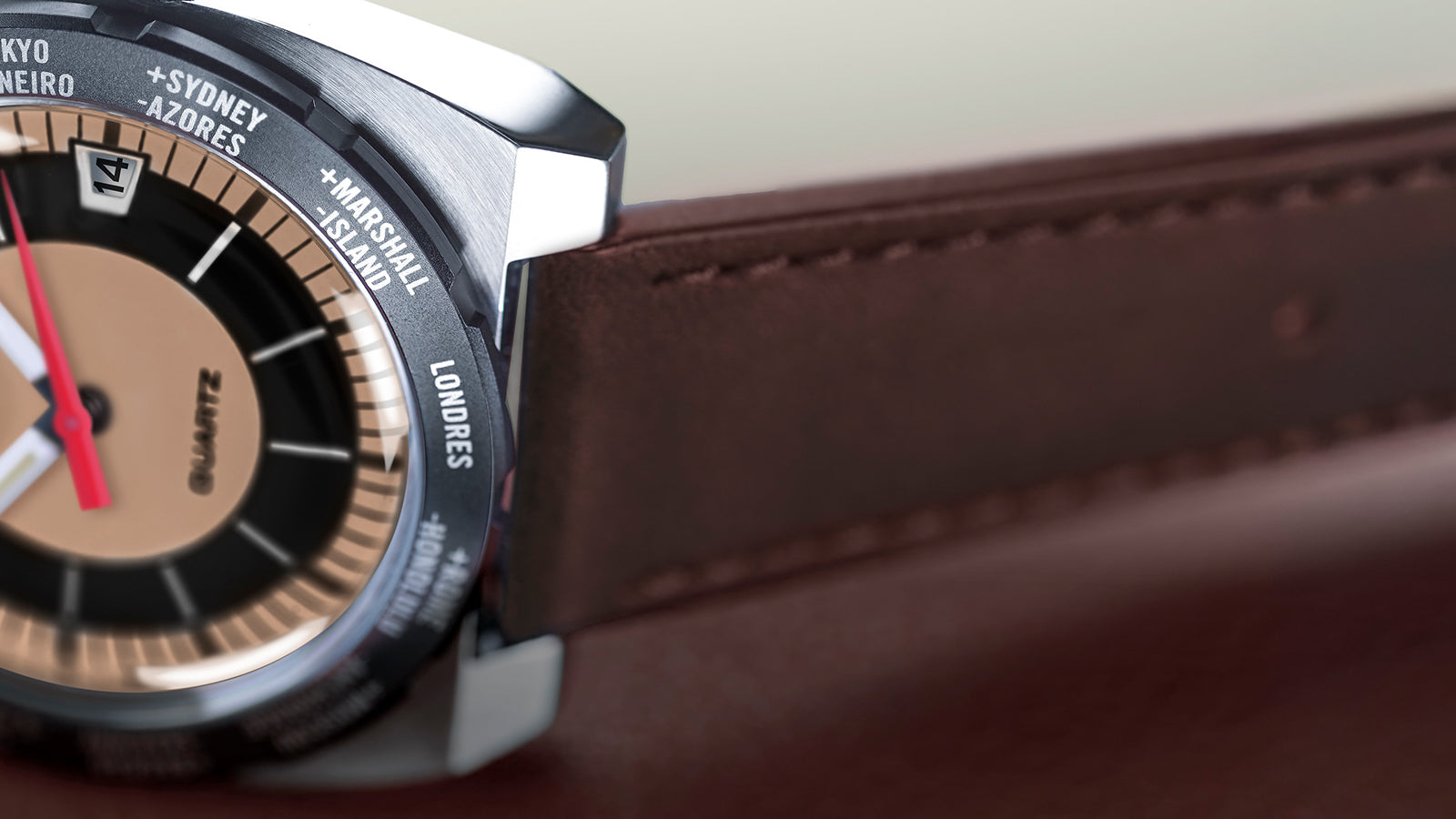 Close-up macro of the Q Timex® 1972 World Time bezel showing engraved city names like London, Sydney, and Tokyo, with polished steel case edges and stitched leather strap.