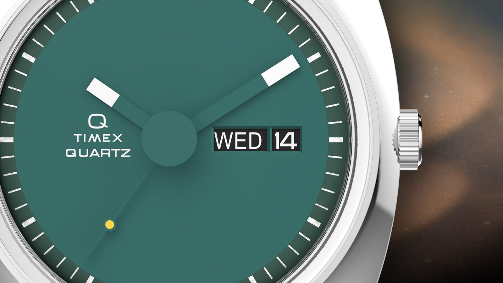Close-up of the Q Timex® 1975 Enigma dial highlighting the minimalist teal face, white rectangular hands, and black day-date window marked Wednesday the 14th.