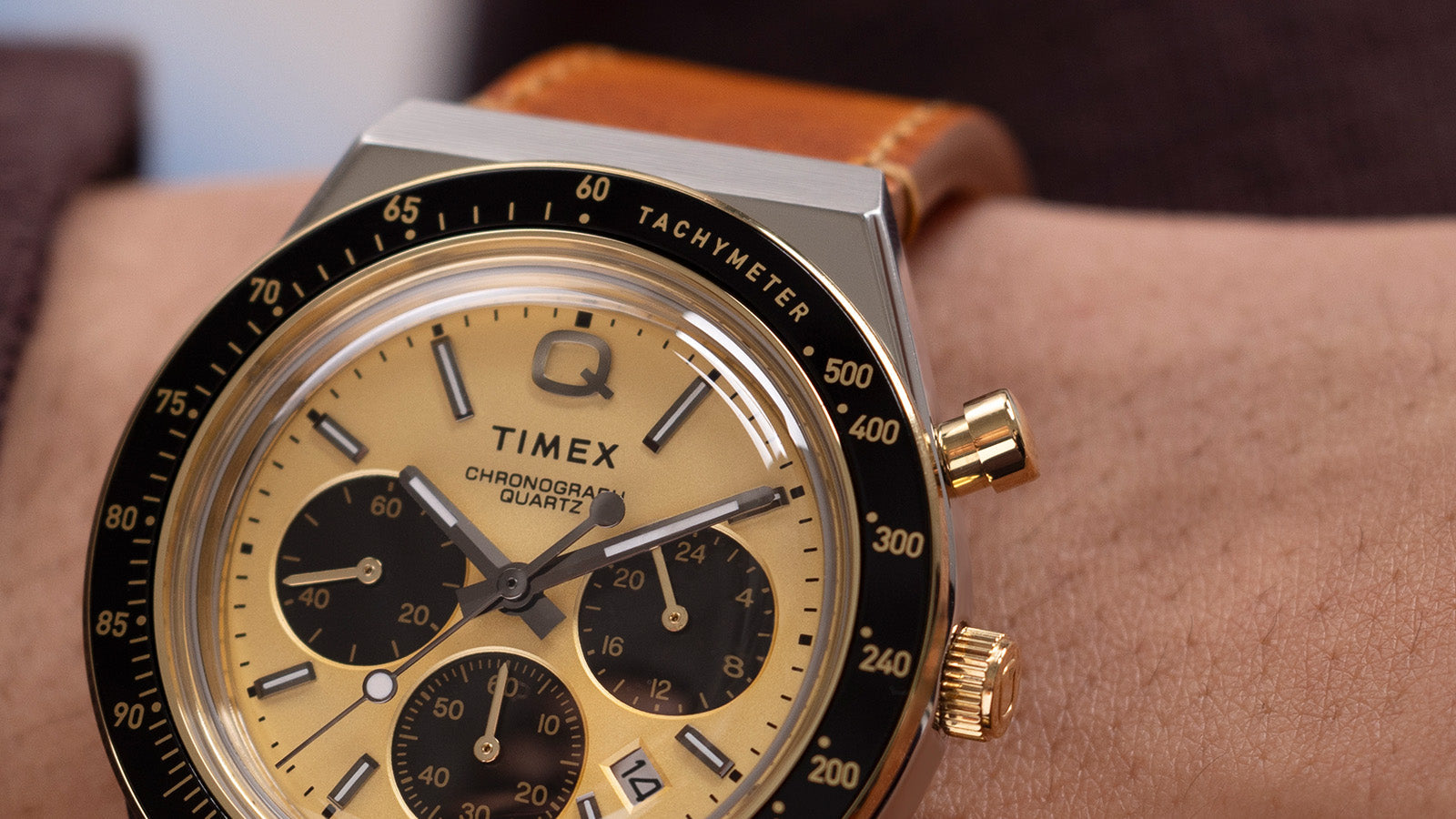 Macro shot showing the Q Timex Chronograph’s gold-tone finish, polished markers, and chronograph sub-dials in precise detail.
