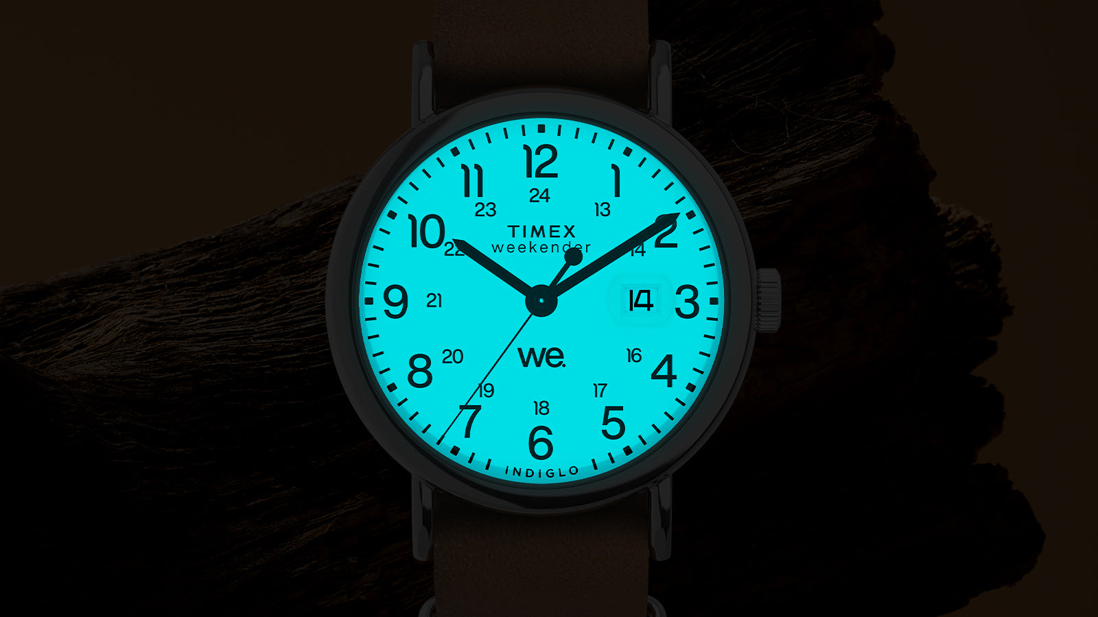 Timex Weekender dial glowing with Indiglo backlight, blue numerals and date window illuminated in the dark.