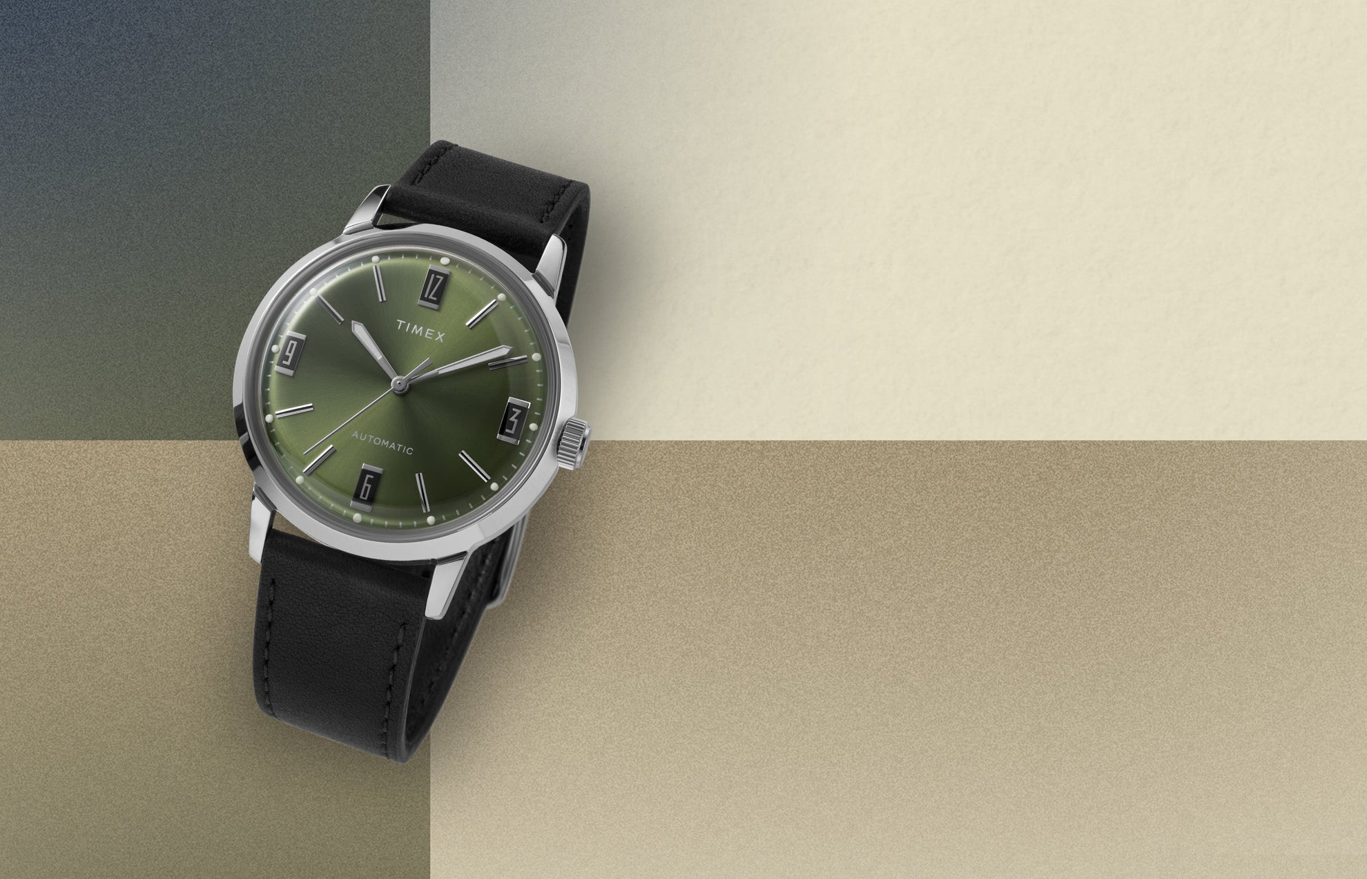 Timex Marlin Automatic watch with green sunray dial and black leather strap displayed on a beige and olive color block background.
