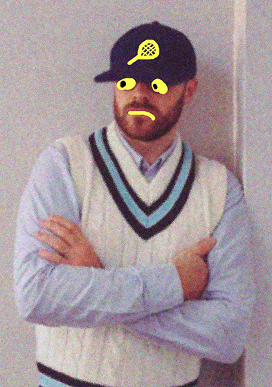 A portrait of a man standing with arms crossed against a neutral wall, wearing a white cricket-style sweater and cap with playful doodles drawn on his face and hat.