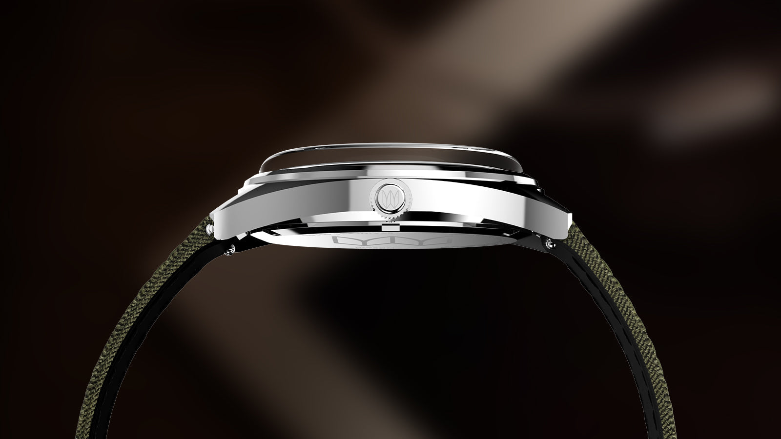 Side profile of the Timex x Bespoke Post watch showing its polished stainless-steel case and slightly curved crystal. The olive green strap adds a rugged, outdoorsy feel to the minimalist silhouette.