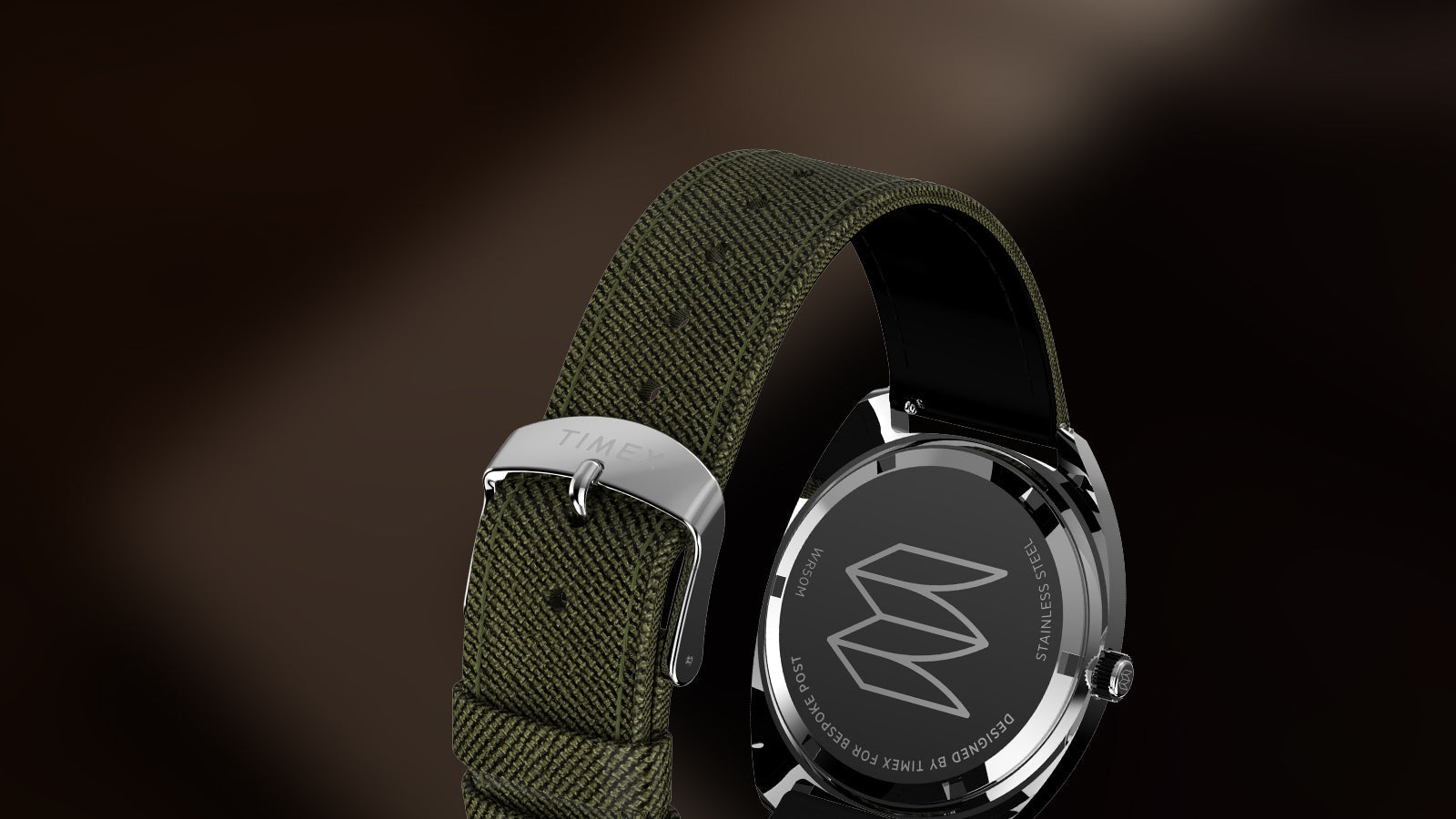 Rear view of the Timex x Bespoke Post watch revealing the stainless-steel case back engraved with the Bespoke Post “M” logo. The olive strap features a polished buckle with the Timex logo.