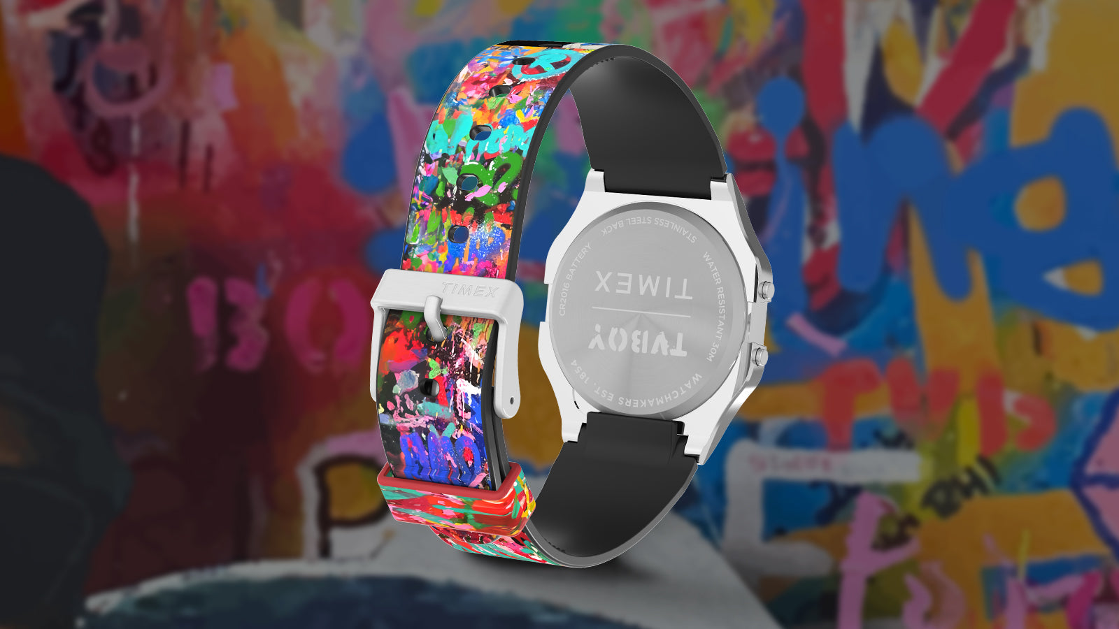 Rear angle view of the Timex T80 x TVBOY watch showing its silver case back engraved with Timex and TVBOY branding. The strap features a graffiti-inspired explosion of color, reflecting TVBOY’s playful street-art aesthetic.