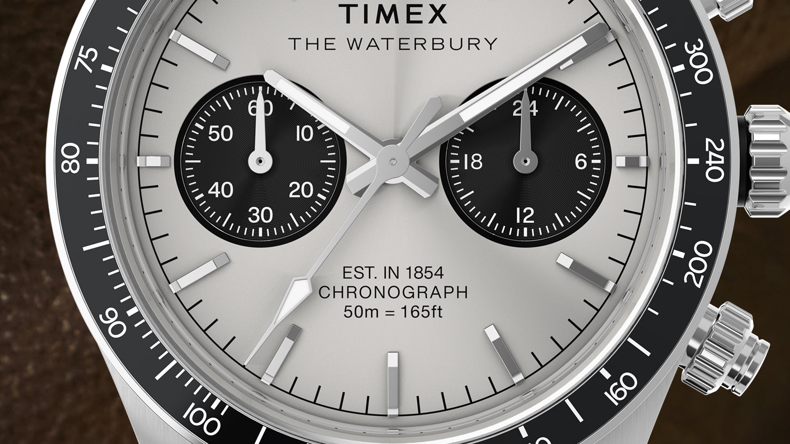 Macro detail of the Timex Waterbury Heritage Chronograph dial, showing black sub-dials, luminous hands, and chronograph markers with “Est. 1854” text.