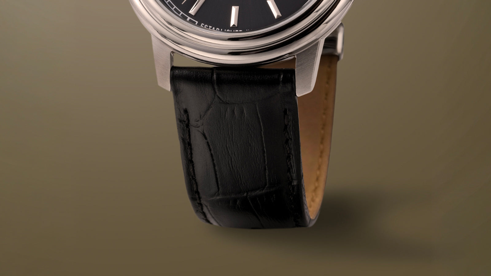 Detailed shot of the Timex Waterbury Metropolitan Automatic’s black leather strap with crocodile-embossed texture and fine stitching.