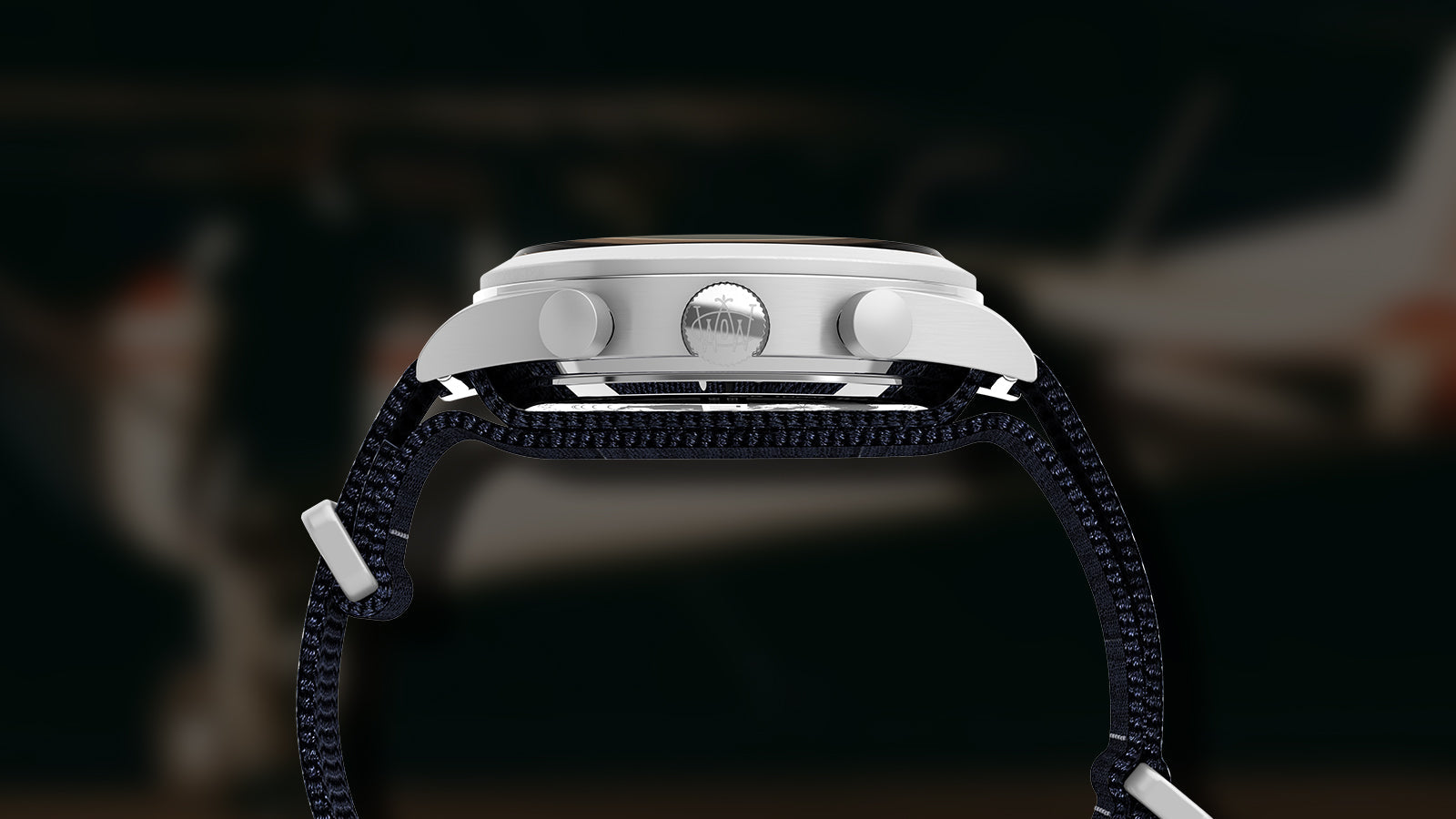 Side view of the Timex Waterbury Traditional Fly-Back Chronograph showing brushed stainless-steel case, crown, and pushers engraved with the Waterbury “W” logo.