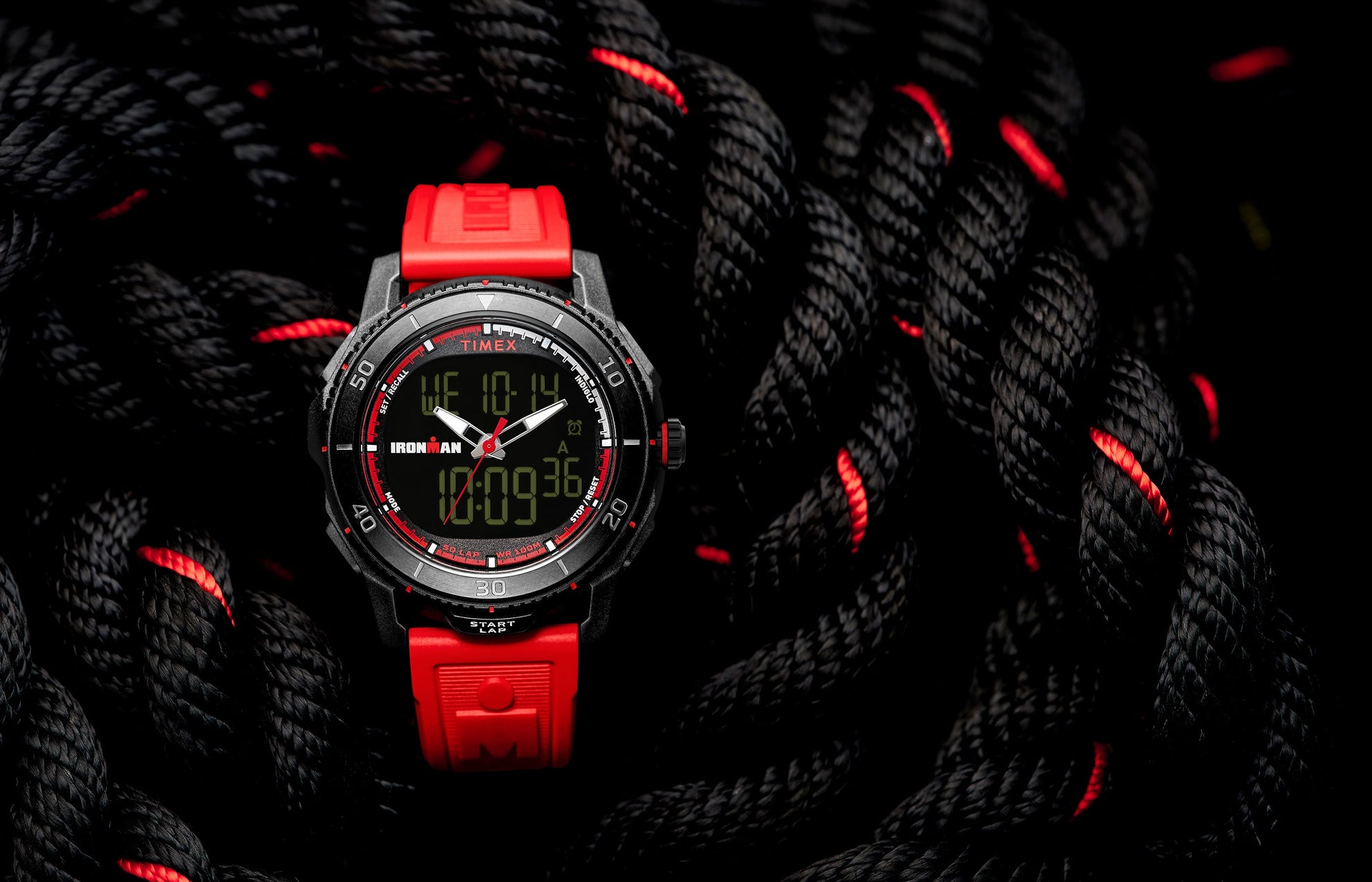 TIMEX® IRONMAN® Adrenaline Ana-Digi watch with black case, red accents, and red resin strap displayed on coiled black rope with red details.