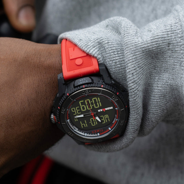 Close-up of the TIMEX® IRONMAN® Adrenaline Ana-Digi watch on wrist, highlighting red strap, rugged design, and digital time display.