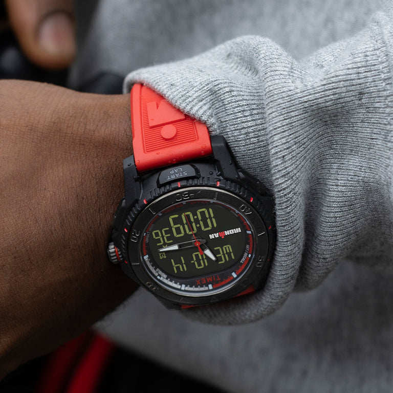 Close-up of the TIMEX® IRONMAN® Adrenaline Ana-Digi watch on wrist, highlighting red strap, rugged design, and digital time display.