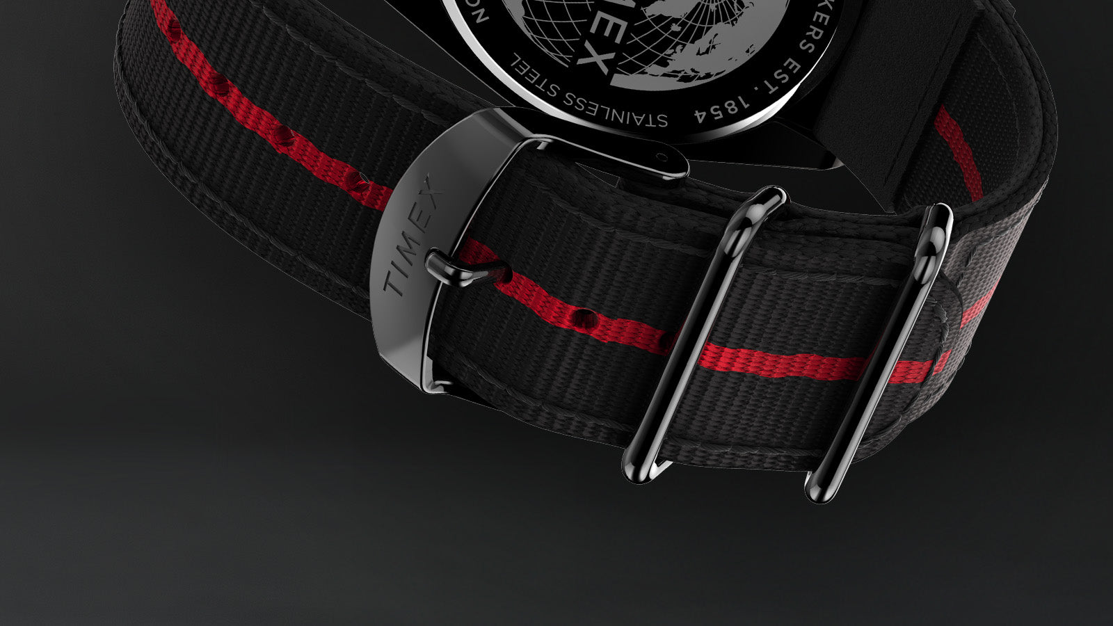 Detailed view of the black fabric strap on the Timex Legacy Tonneau Chronograph featuring a red center stripe and polished hardware engraved with “Timex.”