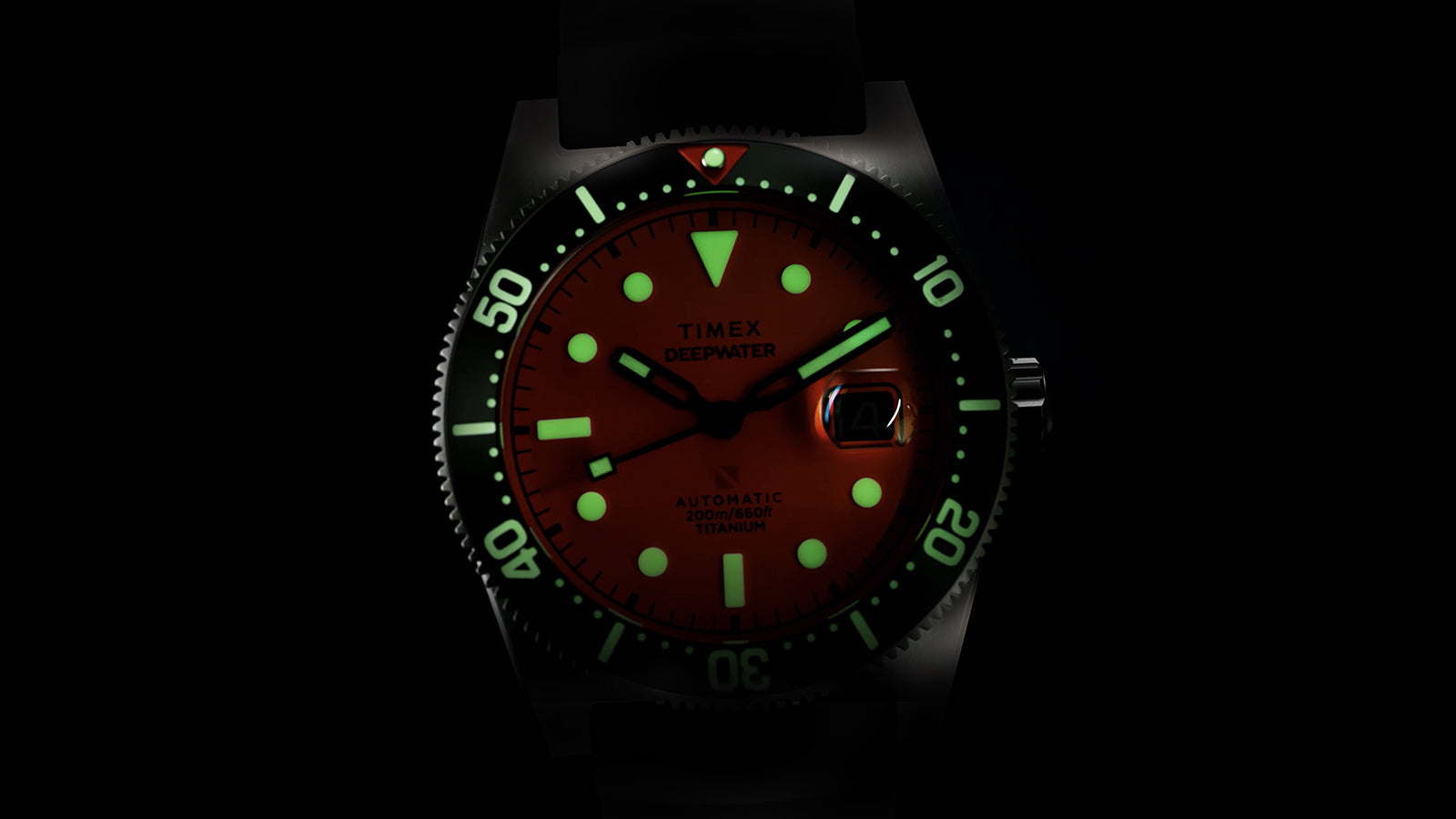 Side profile of the Timex Deepwater Reef 200 focusing on the brushed titanium case, screw-down crown with a red accent, and black rubber strap.