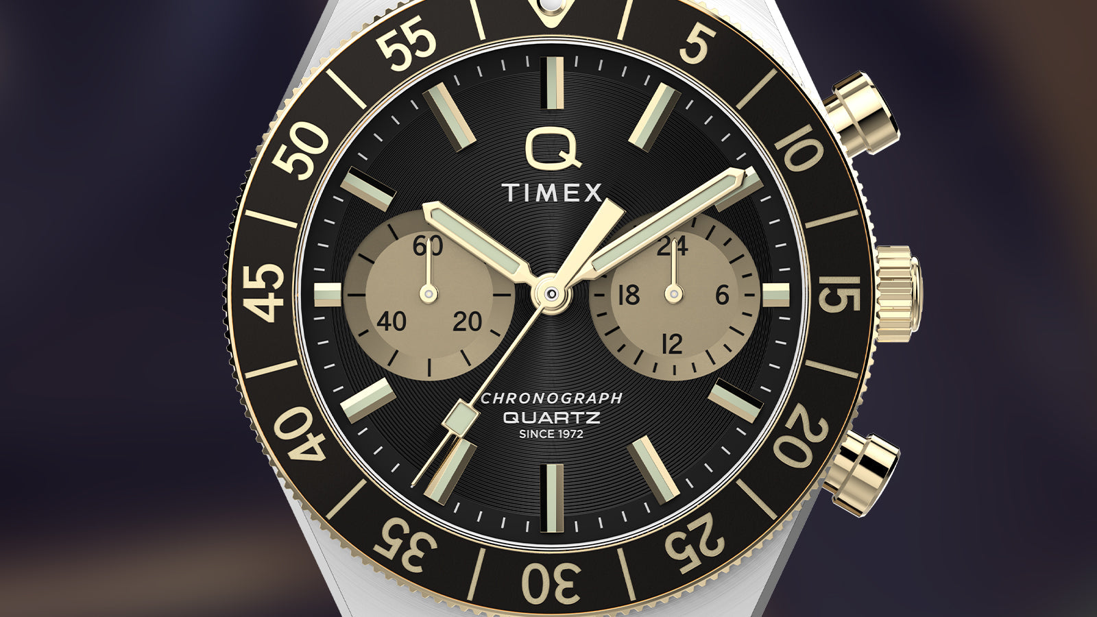 Close-up of the Q Timex® Continental Chronograph dial with black face, champagne chronograph subdials, gold-tone markers, and rotating bezel.