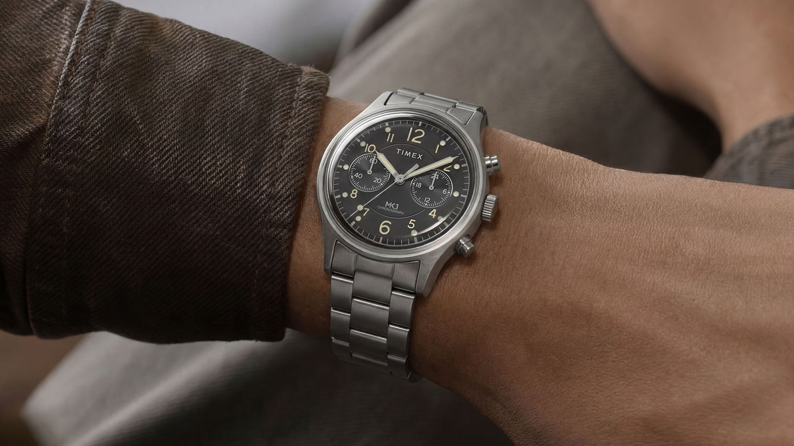 Timex MK1 Chronograph worn on wrist, showcasing the stainless steel bracelet, black dial, and luminous details.