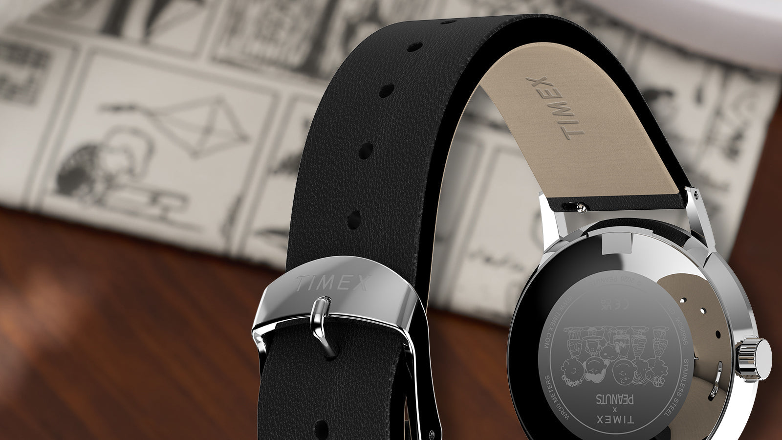 Caseback view of Peanuts® x Timex Marlin® Pickleball watch featuring engraved Peanuts characters, stainless-steel back, and black leather strap with Timex buckle.