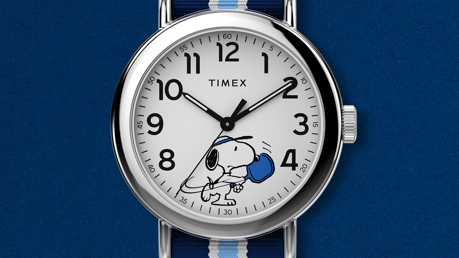 Detailed view of Peanuts® x Timex Weekender® Pickleball stainless-steel case with white dial and blue striped fabric strap.