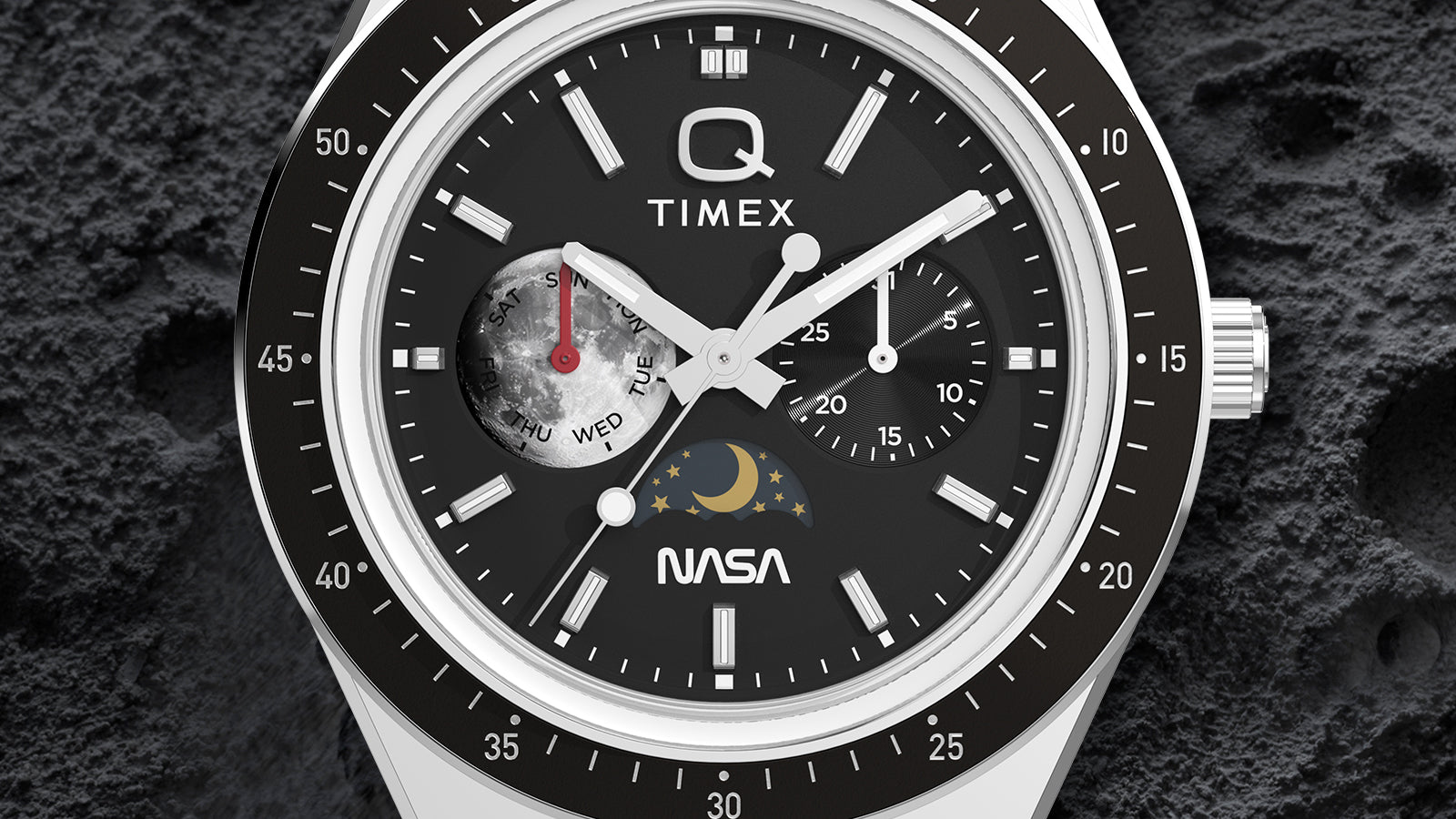 Macro detail of Q Timex® x NASA dial highlighting moonphase display, day subdial, black timing bezel, and applied hour markers.