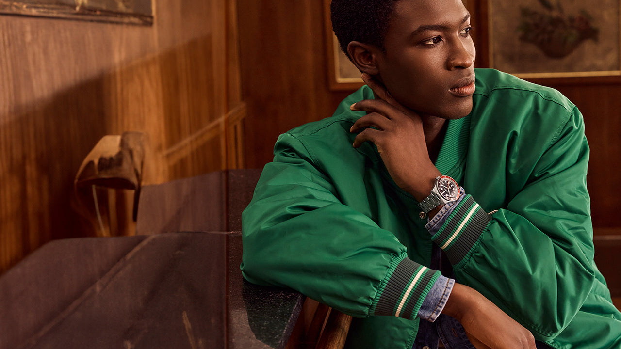 Man wearing a Timex Waterbury GMT automatic watch with a stainless steel bracelet and black dial.