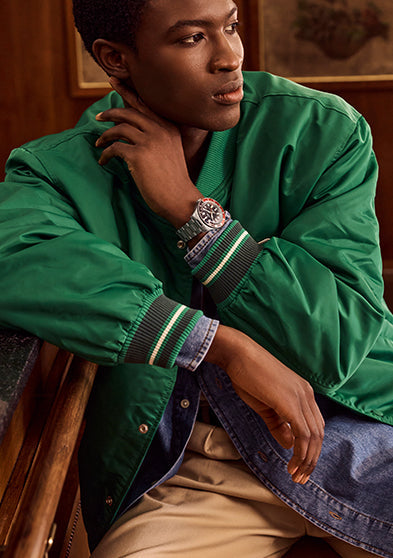 Man wearing a Timex Waterbury GMT automatic watch with a stainless steel bracelet and black dial.