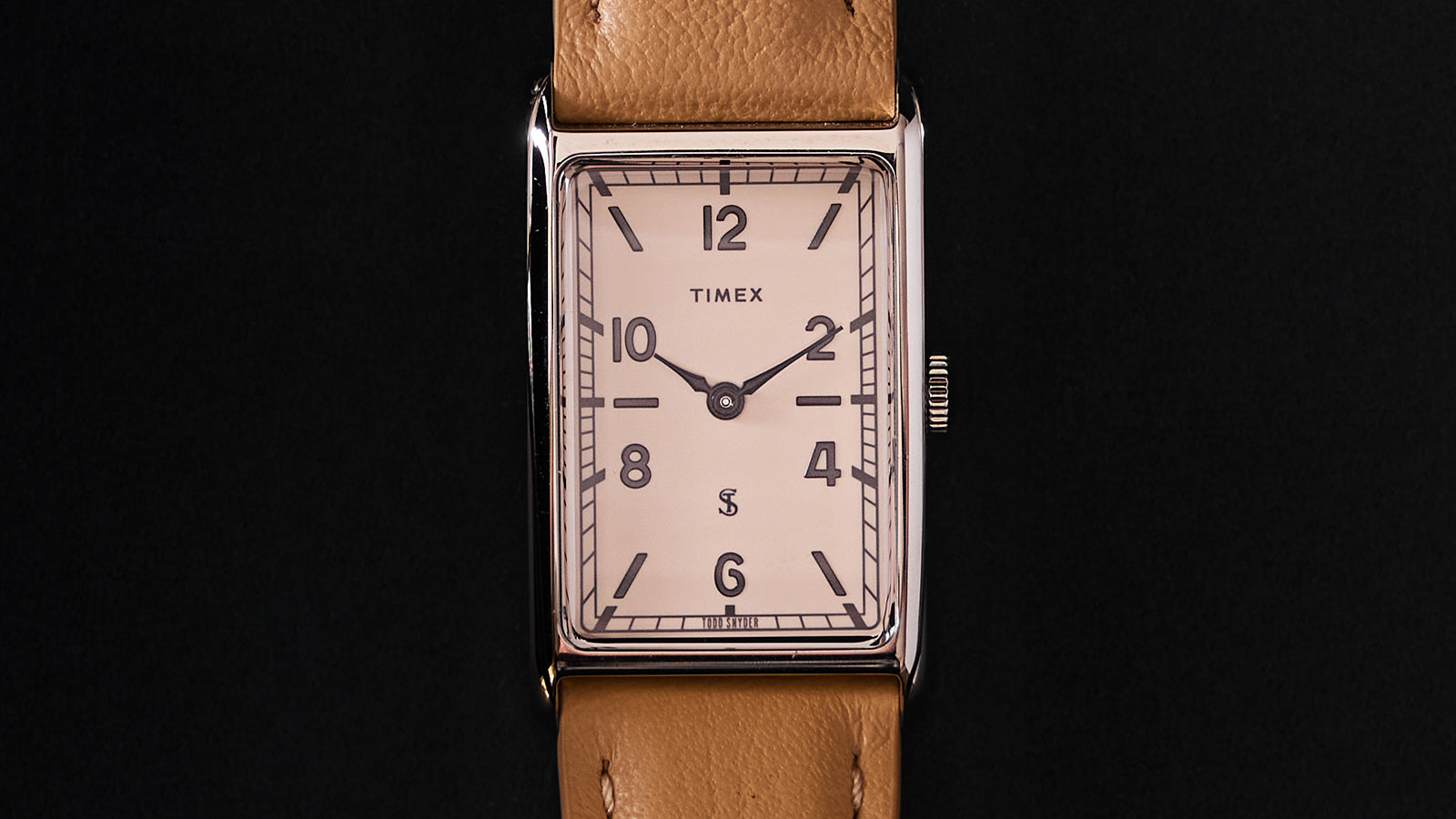 Close-up of the Timex x Todd Snyder 1976 Lexington watch face featuring a cream dial, Arabic numerals, and rectangular case.