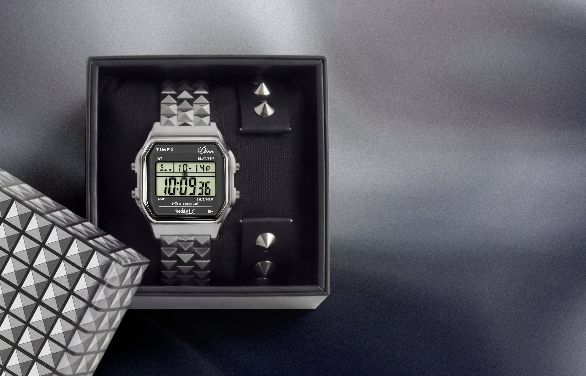 Timex x Dime digital watch set in box with interchangeable studded strap and stainless steel bracelet.