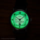 Harry Potter x Timex Weekender Slytherin watch illuminated in green INDIGLO mode showing Slytherin name and serpent crest.