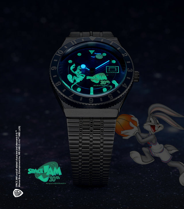 Space Jam x Timex Q 30th Anniversary watch glowing in the dark, featuring Bugs Bunny and basketball hoop on luminous dial against a starry space background
