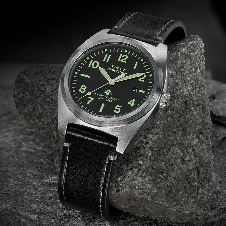 Timex Expedition Capstone watch with black dial and black leather strap on rock surface