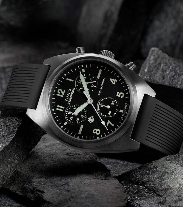 Timex Expedition Capstone Chronograph with black dial and rubber strap resting on rugged rocks