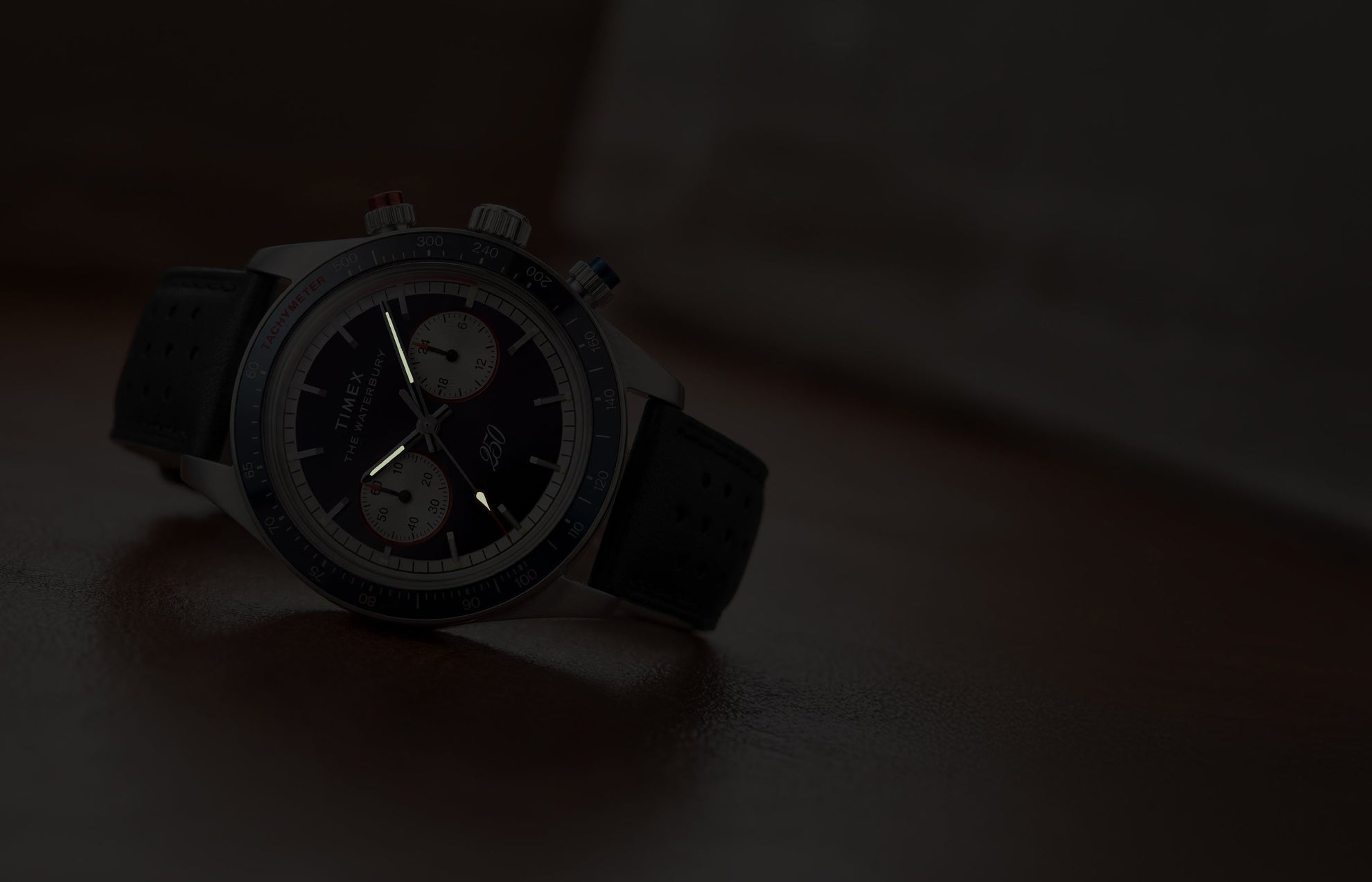 Waterbury Heritage America 250 Chronograph watch showcasing luminous hands and markers in low-light conditions.