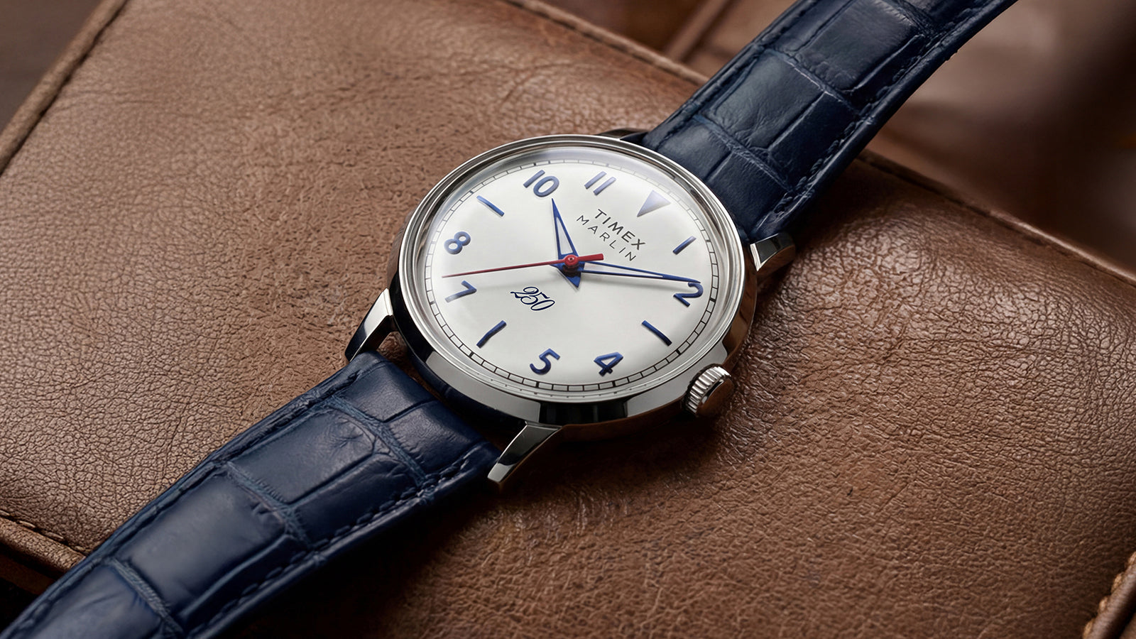 Marlin America 250 watch featuring a polished stainless-steel case, white dial, blue markers, and blue leather strap.