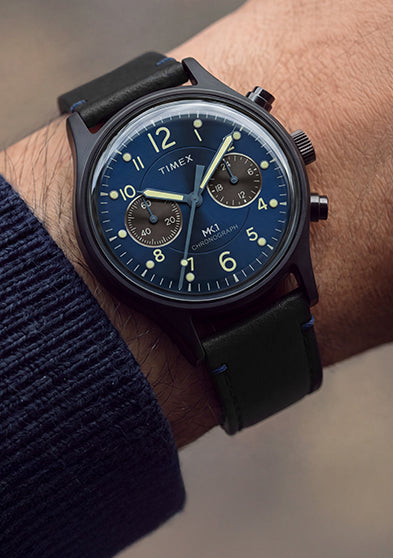 Close-up of the Timex MK1® Chronograph with a blue dial and black leather strap worn on the wrist.