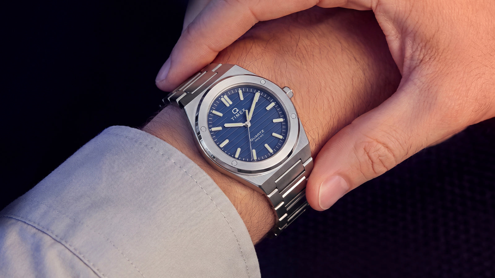 Close-up of the Timex Q Marbella stainless steel watch with a blue dial worn on the wrist.